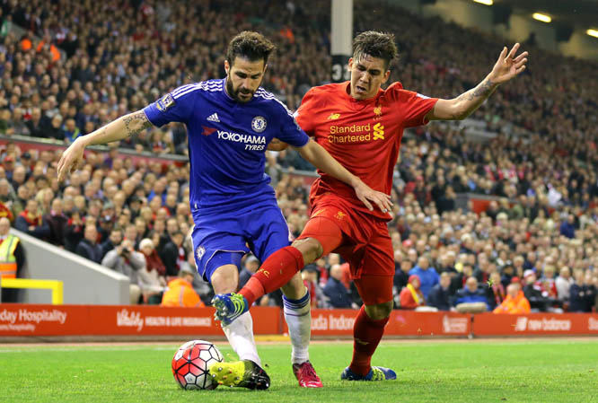 Liverpool's Roberto Firmino (right) and Chelsea's Cesc Fabregas battle for the ball during the English Premier League soccer match at Anfield, Liverpool, England on Wednesday.