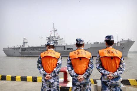 Soldiers from the Chinese People's Liberation Army (PLA) Navy watch as the USS Blue Ridge arrives at a port in Shanghai.