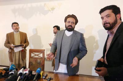Amin Karim, second right, an official of the Hezb-i-Islami Party, speaks as he leaves after a press conference in Kabul, Afghanistan.
