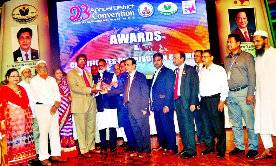 District Governor of Lions Club International Ln. SM Wahiduzzaman Babur, MJF handing over crests to lions members including Chairman of Sariatpur Eye Hospital Dr Alamgir Moti at 23rd Annual District Convention of Lions Club International at Sonargaon Hote