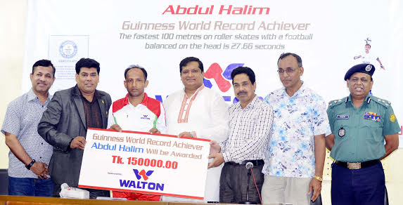 Walton Group handing over a cheque of Tk 1,50,000 and a crest to Abdul Halim, who wrote his name into the Guinness Book of World Records recently. Chairman of the Parliamentary Standing Committee on the Ministry of Youth and Sports Zahid Ahsan Russel, MP,