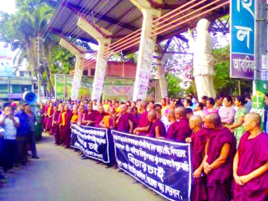 People of Buddhist Community formed a human chain at Mukta Mancha on Sunday protesting killing of Mong U Chak in Baishari Chakpara in Bandarban.