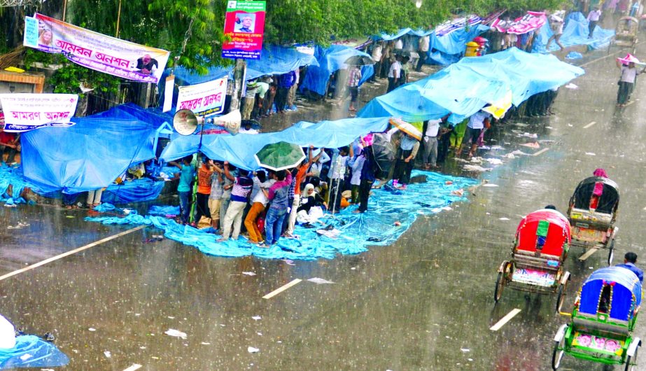 People of various organisations who thronged the Jatiya Press Club in connection with different programmes took shelter under the banners during heavy rains on Wednesday.