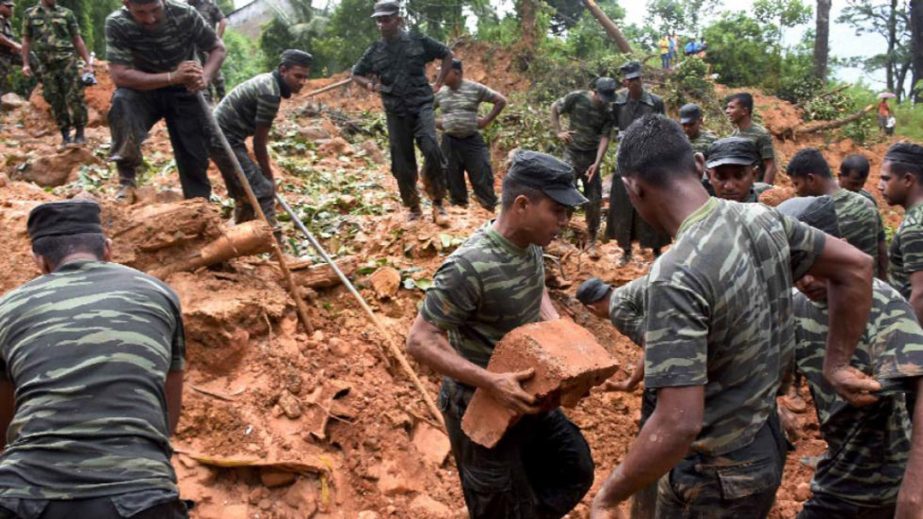 Sri Lankan military personnel take part in relief and rescue efforts following a landslide in the village of Bulathkohupitiya.