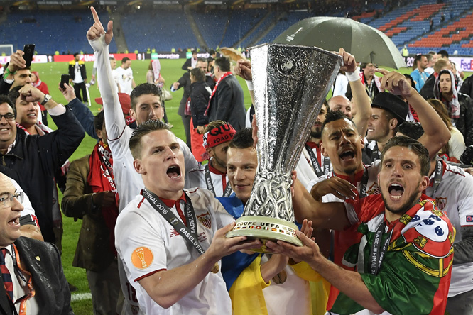 Sevilla players celebrates the victory with the trophy after winning 3-1 in the soccer Europa League final between England's Liverpool FC and Spain's Sevilla Futbol Club at the St Jakob-Park Stadium in Basel, Switzerland on Wednesday.