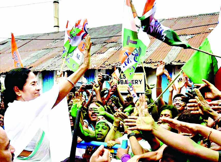 West Bengal CM Mamata Banerjee waves at supporters after her partys thumping win in West Bengal Assembly elections, in Kolkata.