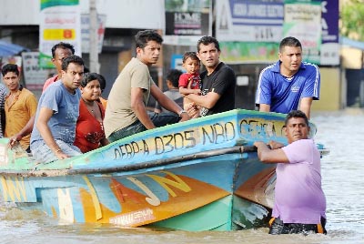 Sri Lankan volunteers evacuate residents by boat following flooding in the Colombo suburb of Kaduwela.