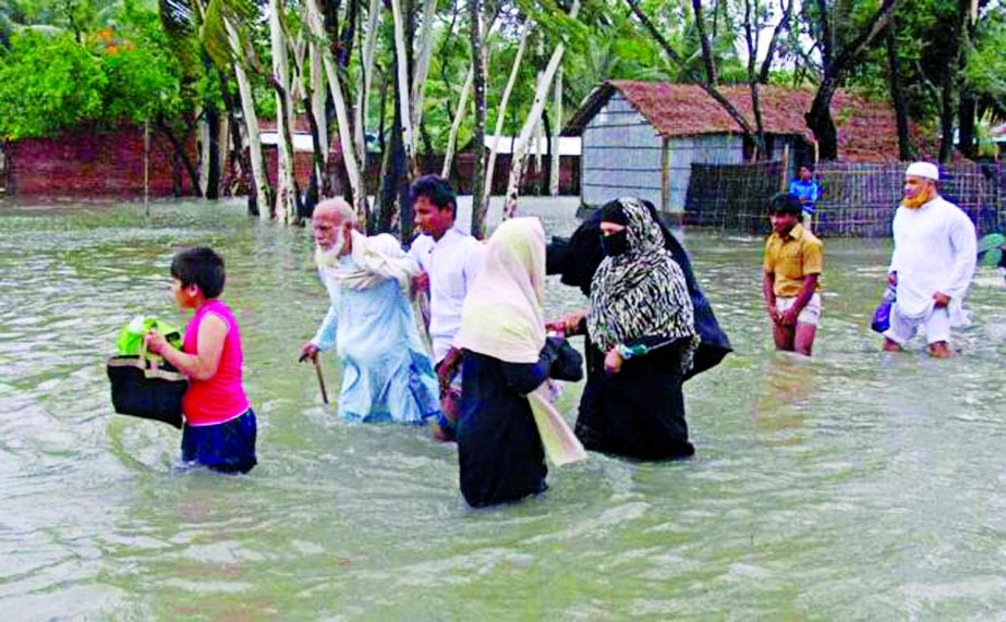 People affected by floods caused due to cyclonic storm 'Roanu' being shifted from Samity Para in Chittagong to a safer place for shelter (top) and houses being damaged in Jhalakati due to flood waters caused by Roanu which hit the Barisal coastal areas