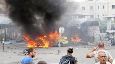 A Syrian army soldier and civilians inspect the damage after explosions hit the Syrian city of Tartous, in this handout picture provided by SANA on Monday.