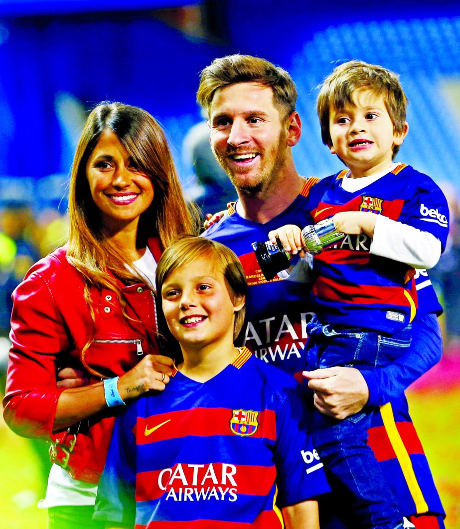 Barcelona's Lionel Messi, carrying his son, posses for a photo with his wife Antonella Roccuzzo as they celebrate after winning the final of the Copa del Rey soccer match between FC Barcelona and Sevilla FC at the Vicente Calderon stadium in Madrid, Sund