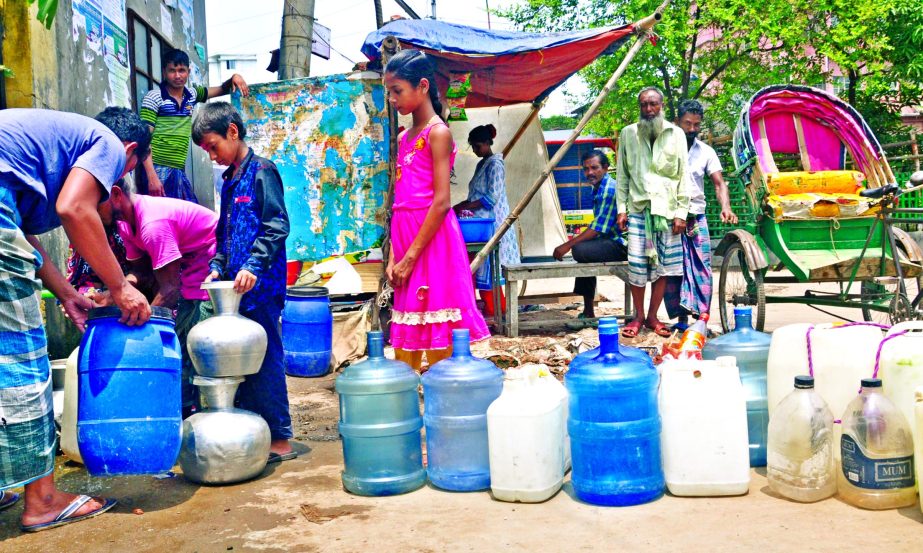 Due to acute shortage of water people of city's Saidabad area are seen collecting water from a WASA pump house on Monday.