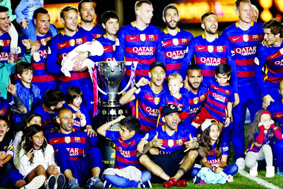 Barcelona players pose for a photo as they celebrate their last two titles at the Camp Nou stadium in Barcelona, Spain, Monday.. Barcelona's added the Copa del Rey to its Spanish league title on Sunday, but fell short of repeating its treble from last se