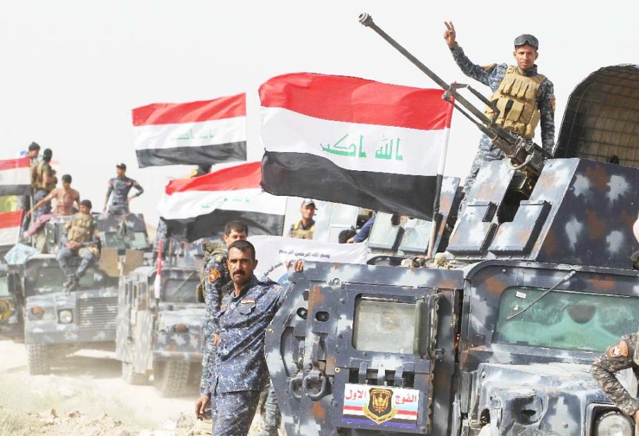 Iraqi pro-government forces gather in al-Shahabi village, east of the city of Fallujah, on Tuesday.