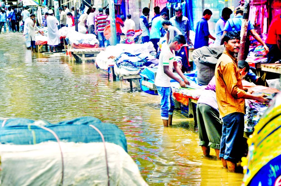 Due to poor drainage system a major portion of Motijheel hub in city makeshift owners standing on the ankle-deep water as rain water being stagnant. This photo was taken from near Sonali Bank Head Office on Friday.