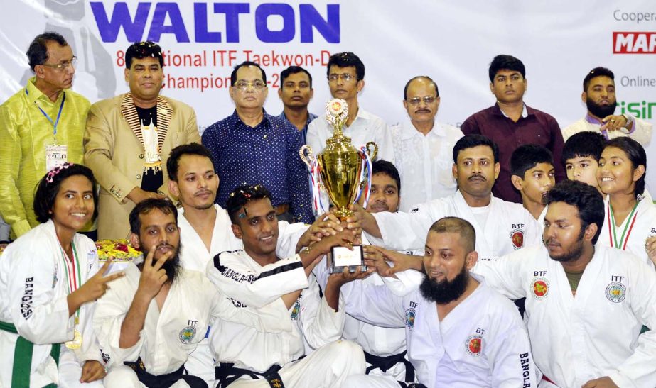 Bangladesh Ansar, the champions of the Walton 8th National Taekwondo Competition with the guests and the officials of Bangladesh Taekwondo Federation pose for a photograph at the Gymnasium of Bangladesh National Sports Council on Tuesday.