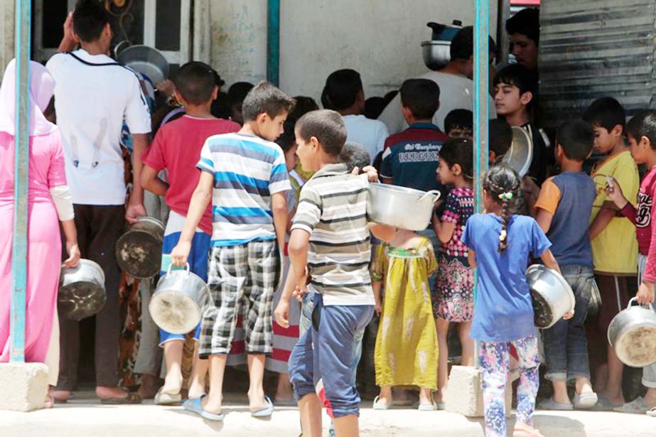 Displaced Iraqis who fled fighting between government forces and the Islamic State (IS) group in Anbar province line up to collect donated food at the Alexanzan camp in the Dora neighbourhood on the southern outskirts of Baghdad on Tuesday.