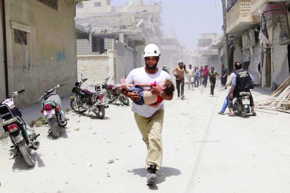 A civil defence member carries an injured girl at a site hit by airstrikes in the rebel-controlled area of Maaret al-Numan town in Idlib province on Thursday.