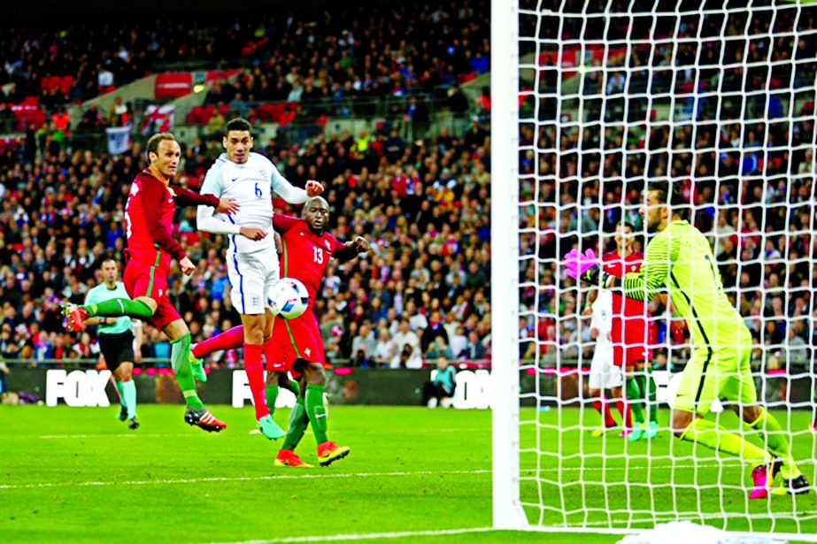 England's Chris Smalling (second left) scores his team's first goal during the International Friendly soccer match against Portugal at Wembley Stadium, London on Thursday.