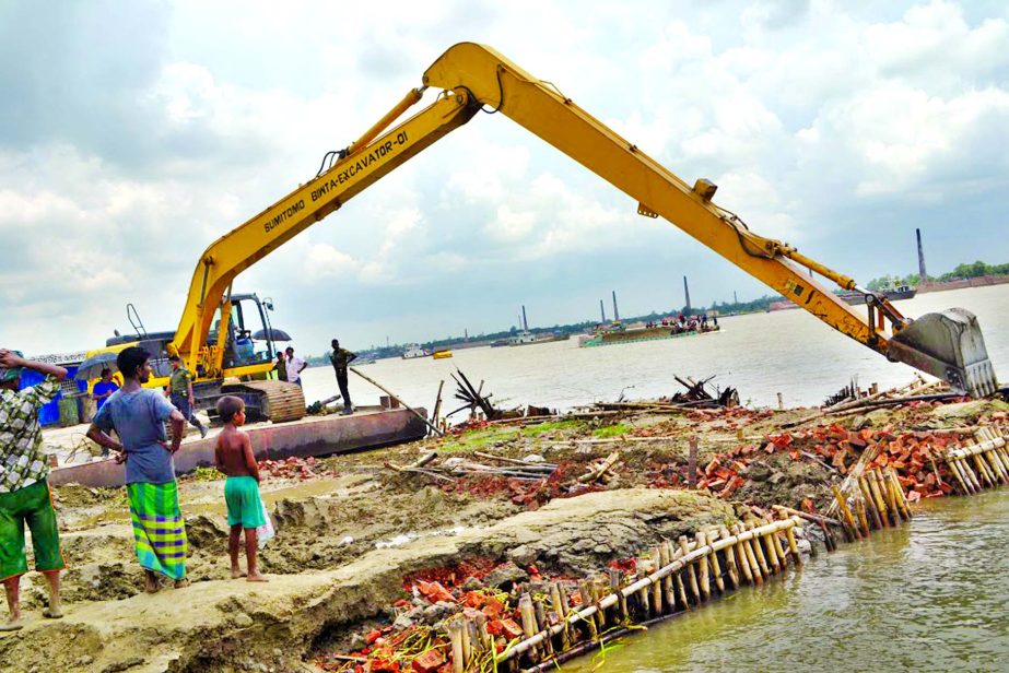 Unauthorised structures on the bank of Dhaleswari River in Narayanganj being bulldozed by BIWTA authorities on Monday.