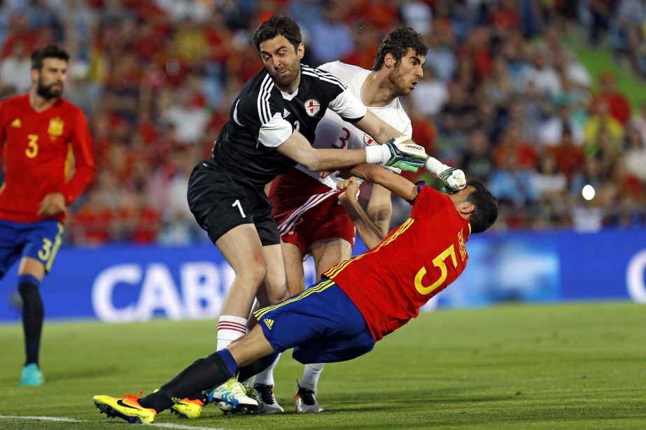 Spain's Sergio Busquets (right) clashes with Georgia's goalkeeper Nukri Revishvili (left) during a friendly soccer match between Spain and Georgia at the Alfonso Perez stadium in Getafe, on the outskirts of Madrid on Tuesday. Spain lost the game 0-1.