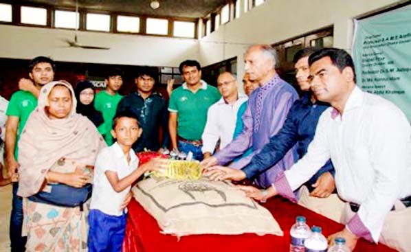 Dhaka University Vice-Chancellor Prof Dr AAMS Arefin Siddique handing over foodstuffs among the under-privileged children and their families organized by Human Safety Foundation at TSC Cafeteria of the University recently.