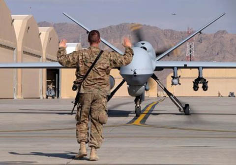 A US airman guides a U.S. Air Force MQ-9 Reaper drone as it taxis to the runway at Kandahar Airfield, Afghanistan.