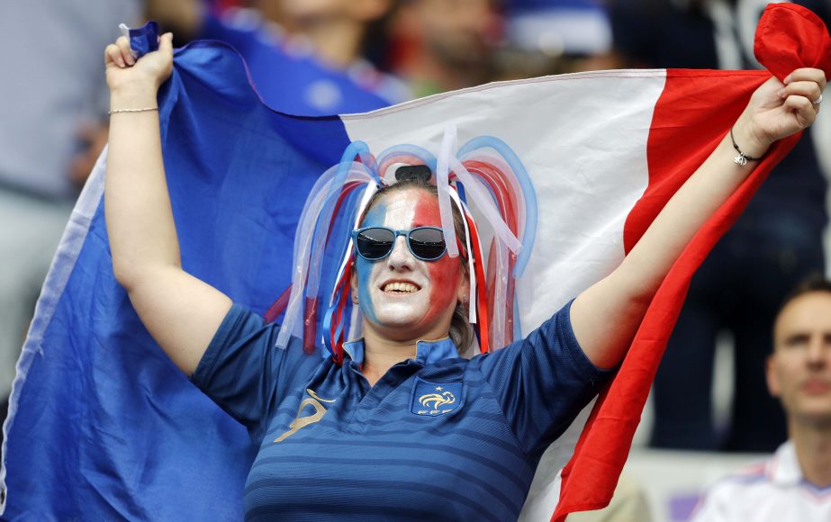 A France supporter, her face painted in the colors of the French national flag, cheers prior to the Euro 2016 Group A soccer match between France and Romania at the Stade de France in Saint-Denis, north of Paris on Friday.