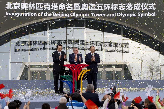 From left to (right) Beijing Mayor Wang Anshun, International Olympic Committee (IOC) President Thomas Bach, and Liu Peng, Minister of the General Administration of Sport of China applause on stage after the inauguration of the Beijing Olympic Tower and O