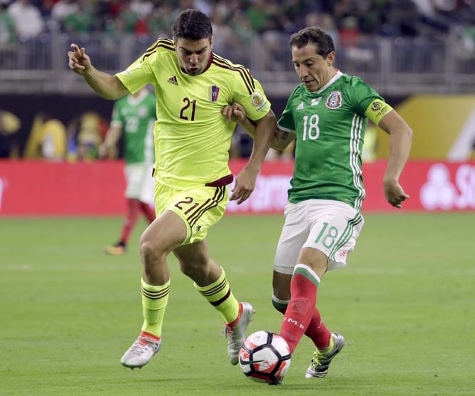 Mexico midfielder Andres Guardado (18) dribbles the ball as Venezuela defender Alexander Gonzalez (21) move in during a Copa America Centenario group C soccer match in Houston on Monday.