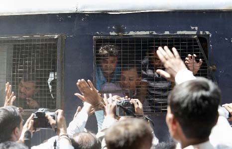 Indian Hindus convicted of involvement in fatal riots are surrounded by media and relatives as they are taken from a court in a police van in Ahmedabad.