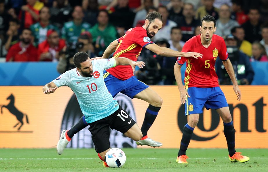 Spain's Juanfran fights for the ball with Turkey's Arda Turan (left) during the Euro 2016 Group D soccer match between Spain and Turkey at the Allianz Riviera stadium in Nice, France on Friday.