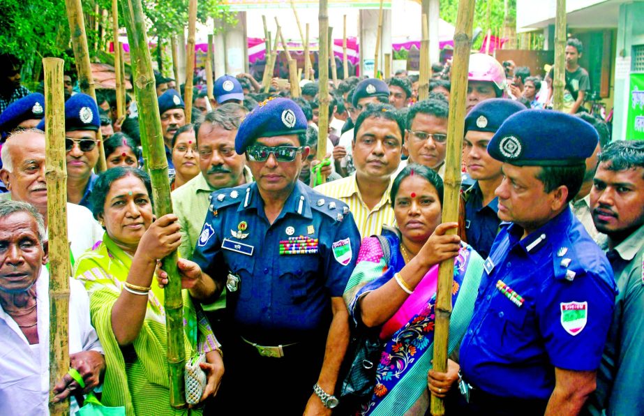 DIG of Khulna Range Moniruzzaman distributing bamboo sticks and whistle to the villagers on the premises of Shamsundar Mandir at Munshipara of Satkhira on Saturday to build up the mass resistance movement against militants unitedly.