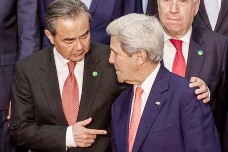 Chinese Foreign Minister Wang Yi (L) speaks with US Secretary of State John Kerry in Paris, France on Friday.