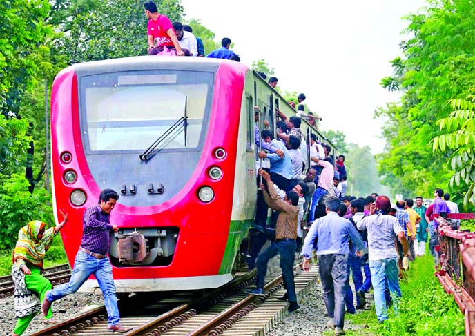 Risking their lives thousands rush everyday to find a place in a Demu Train to avoid continuous road turmoil. This photo was taken from Banani Rly Station on Sunday.