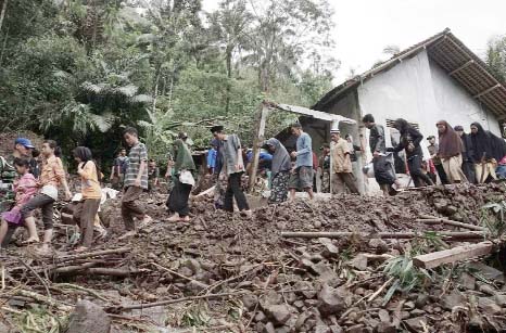 Villagers walk through the area affected by landslides in Banjarnegara, Central Java, Indonesia on Sunday.