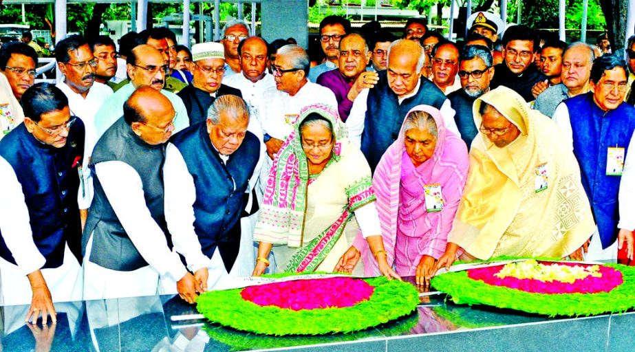 Awami League President and Prime Minister Sheikh Hasina along with party colleagues placing floral wreaths on the portrait of Father of the Nation Bangabandhu Sheikh Mujibur Rahman at 32, Dhanmondi in the city on Thursday marking 67th founding anniversary