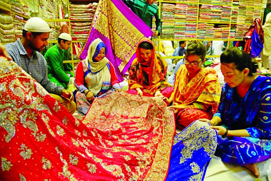 Women are seen busy with their Eid shopping at Benarasi Palli, Mirpur in the city. The area is famous for local sarees, lehengas and three pieces. Lehenga prices range from 5,000 to 1, 25, 000 or above. The picture was taken from a Hanif Silk showroom of