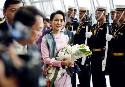 Myanmar Foreign Minister Aung San Suu Kyi, centre, walks past a Thai honor guard as she arrives at the Suvarnabhumi Airport on Thursday.
