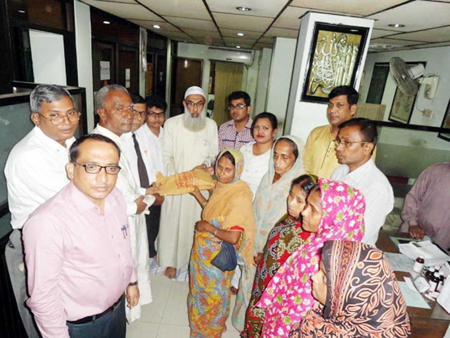 Leaders of the executive committee of the Sangha distributing the Eid dresses among the poor women of the society at its Station Road office in city on Tuesday.