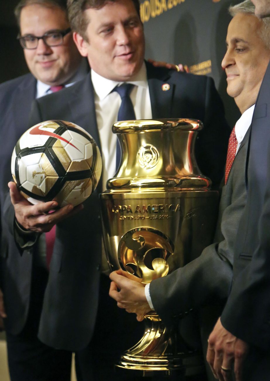 From left to right, CONCACAF President Victor Montagliani, CONMEBOL President Alejandro Dominguez and US Soccer Federation President Sunil Gulati pose with the Copa America Centenario championship trophy during a press conference in New York on Friday. Ar