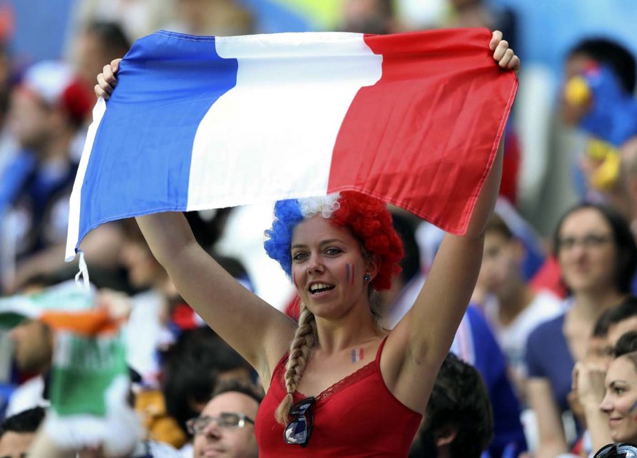 A France's supporter holds a French flag prior to the Euro 2016 round of 16 soccer match between France and Ireland, at the Grand Stade in Decines- Charpieu, near Lyon, France on Sunday.