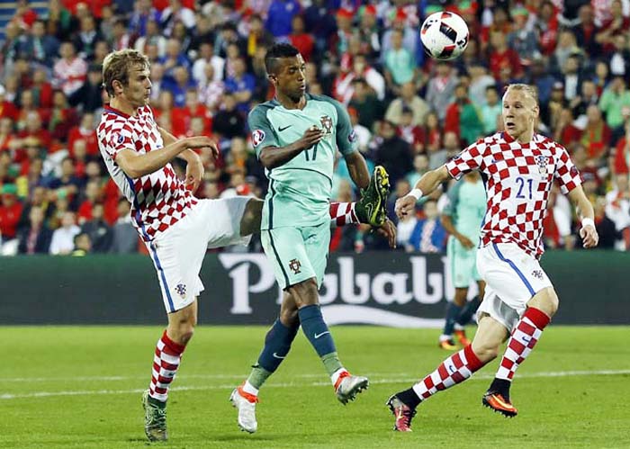 Portugal's Nani (center) is challenged by Croatia's Ivan Strinic (left) during the Euro 2016 round of 16 soccer match between Croatia and Portugal at the Bollaert stadium in Lens, France on Saturday.