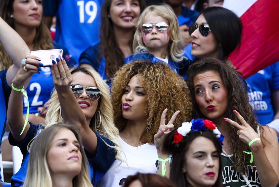Ludivine Payet (left) wife of France's Dimitri Payet, poses for a photo with others on the stands during the Euro 2016 round of 16 soccer match between France and Ireland, at the Grand Stade in Decines-Â­Charpieu, near Lyon, France on Sunday.