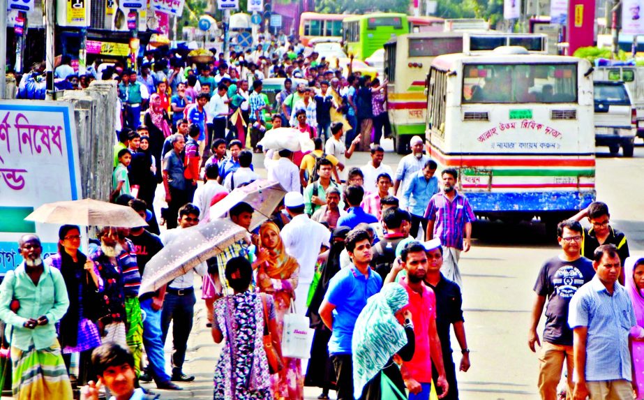 Risking their lives thousands of home-goers crowded the bus stand and battling to find a place inside the bus as non-availability of transports due to traffic gridlock. This photo was taken from Farmgate area on Sunday.