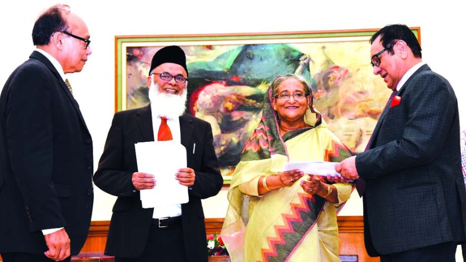 Prime Minister Sheikh Hasina, receiving a cheque of Tk15 million for "Prime Minister's Relief Fund" from A Rouf Chowdhury, Chairman of Bank Asia Ltd at the Prime Minister residence Gonobhabon on Monday. Vice Chairman of the Bank AM Nurul Islam was pres