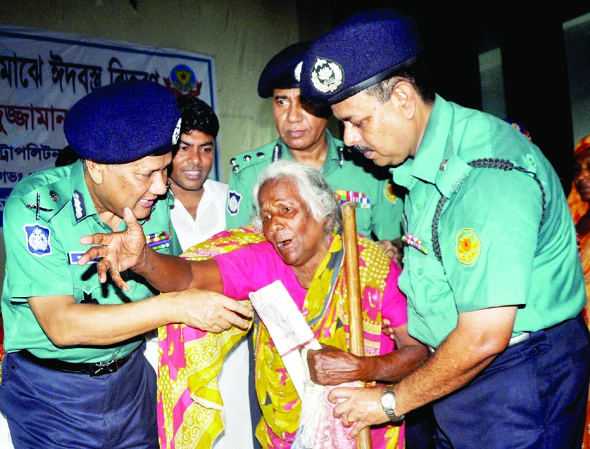 DMP Commissioner Asaduzzaman Mia distributing Eid clothes among the destitute at a programme organised by Dhaka Metropolitan Lalbag Division at Azimpur Girls' High School and College in the city on Monday.