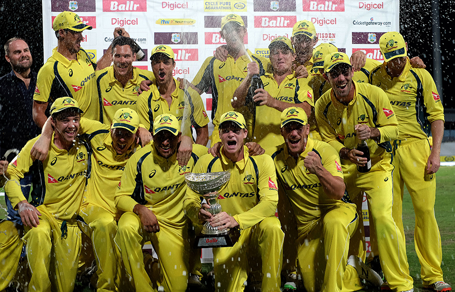 A jubilant Australia side pose with the trophy after their tri-series win against West Indies in ODI tri-series final, at Barbados on Sunday.