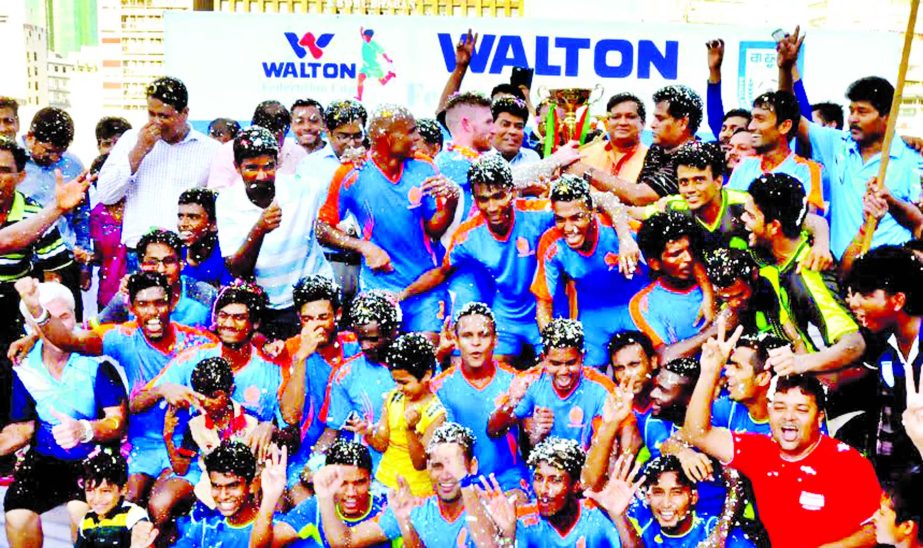 Players of Dhaka Abahani Limited celebrate with the championship trophy of Federation Cup Football at Bangabandhu National Stadium on Monday.