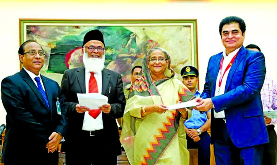 Dr. H.B.M. Iqbal, Chairman of Premier Bank Limited, handing over a cheque of Tk 15 millions to Prime Minister Sheikh Hasina, for PM's Relief Fund at Gonobhaban on Monday. Bank's Managing Director Khondker Fazle Rashid and Bankers Association of Banglade