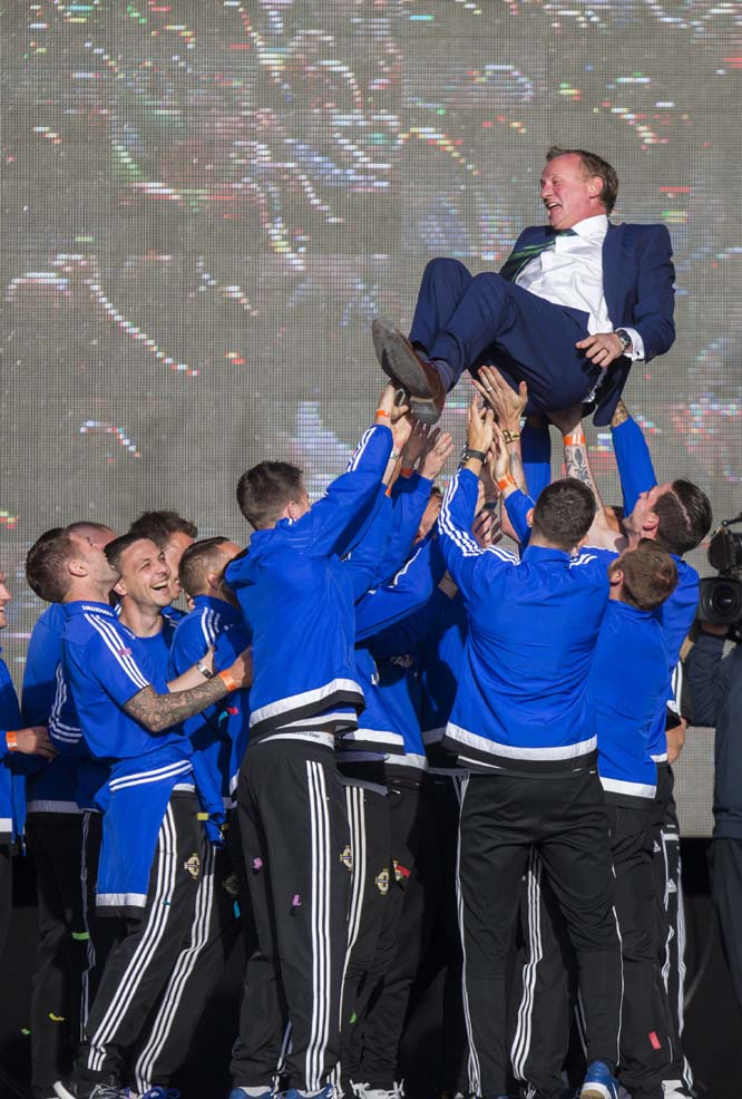 Northern Ireland soccer team players lift manager Michael O'Neill into the air as they celebrate with fans the team's success in the 2016 Euro soccer championship in France, at the Titanic Fanzone in Belfast, Northern Ireland on Monday. The Northern Ire